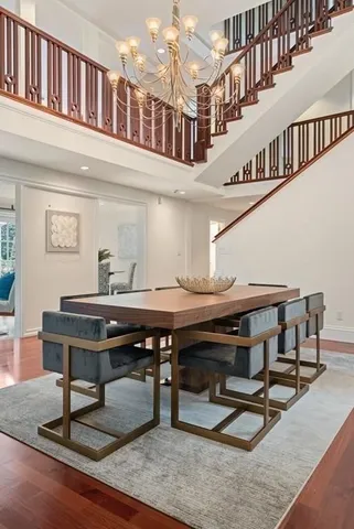 a view of a hall with wooden floor and a dining table chairs