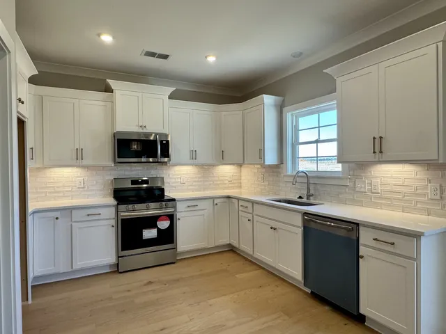 a kitchen with stainless steel appliances granite countertop a sink and a stove top oven