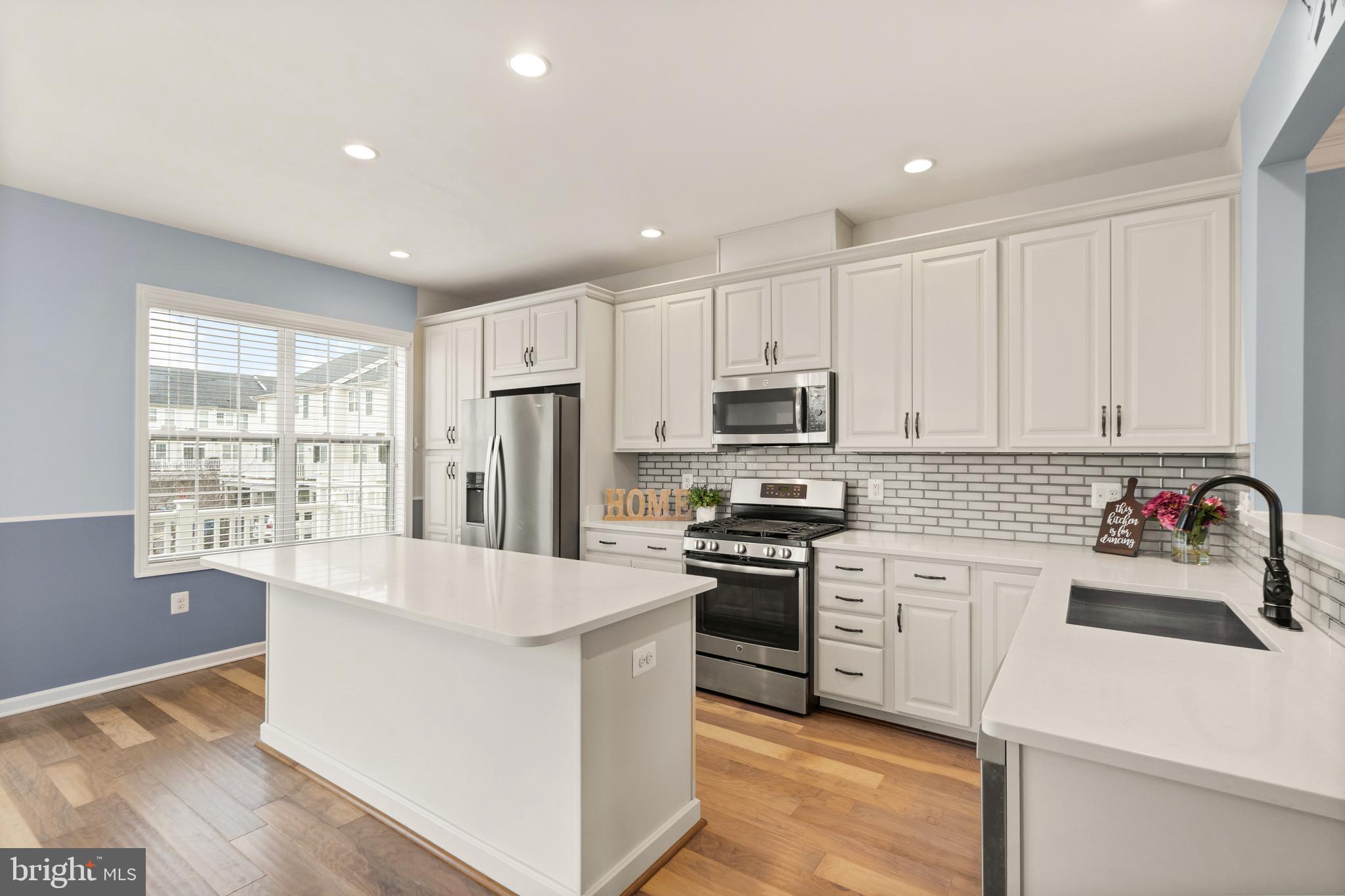 42988 Atoka Manor Terrace Ashburn, VA 20148 - Photo 16 of 47 a kitchen with refrigerator cabinets and wooden floor