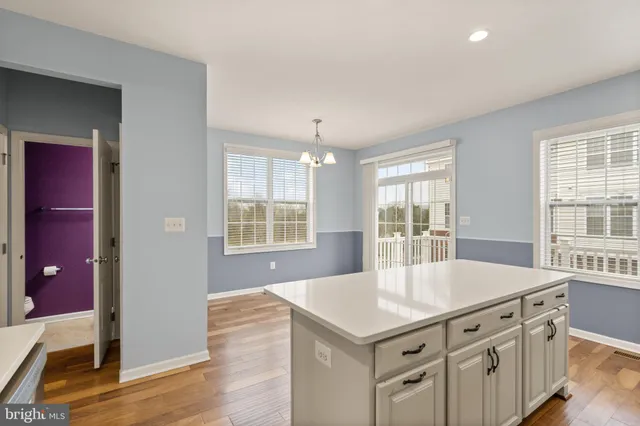 a kitchen with stainless steel appliances a kitchen island hardwood floor and sink
