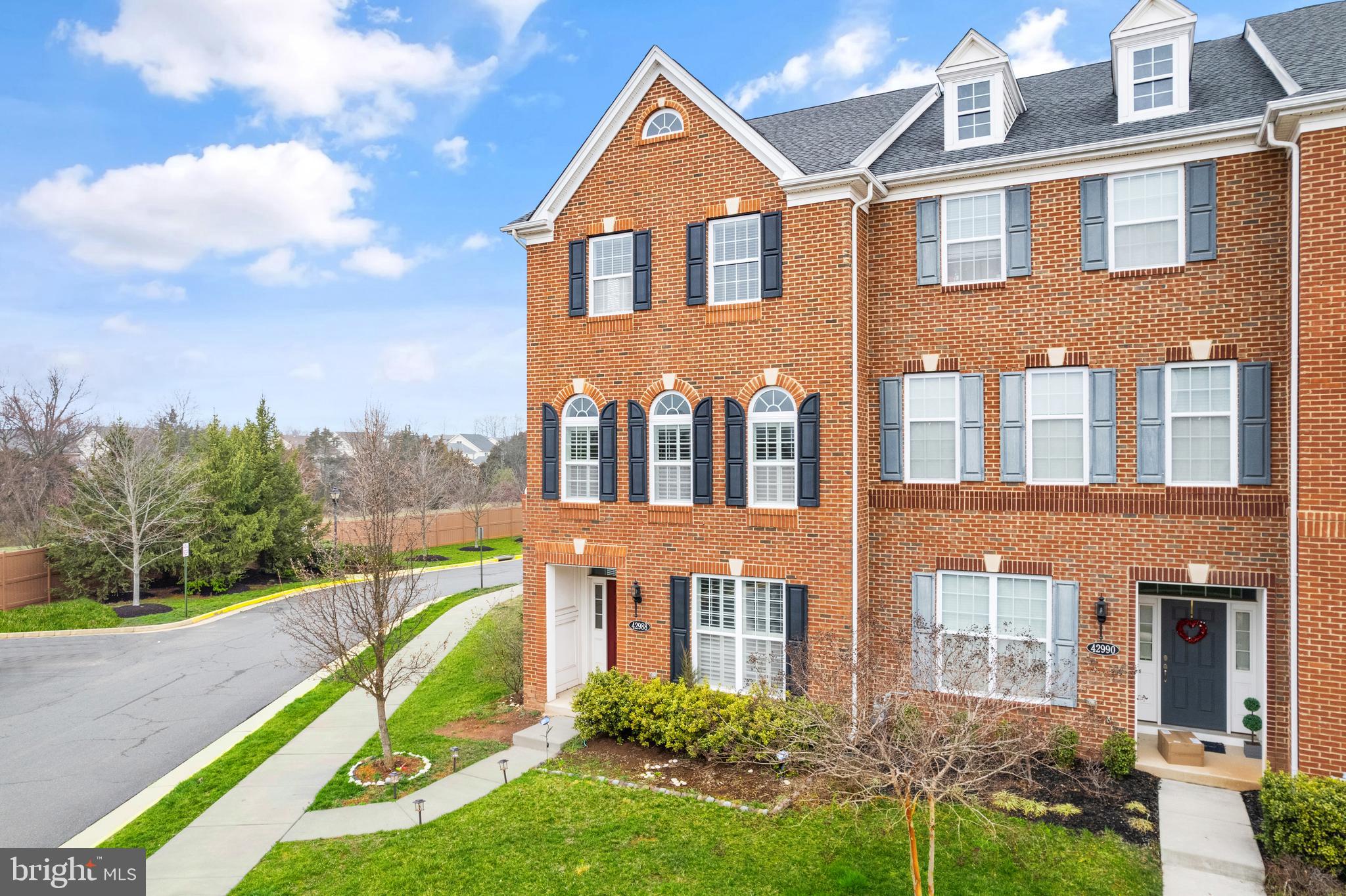42988 Atoka Manor Terrace Ashburn, VA 20148 - Photo 2 of 47 a front view of a house with garden and trees