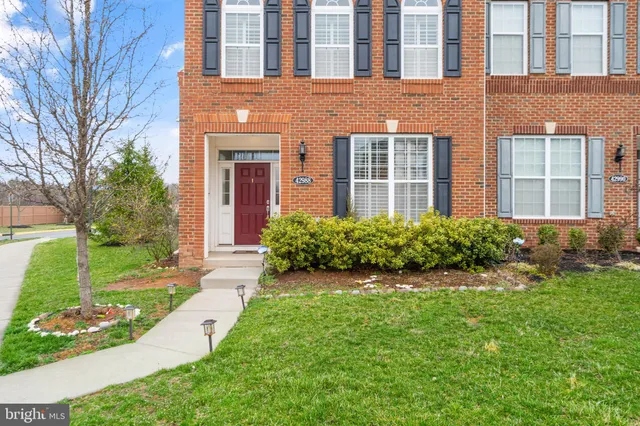 front view of a brick house with a yard