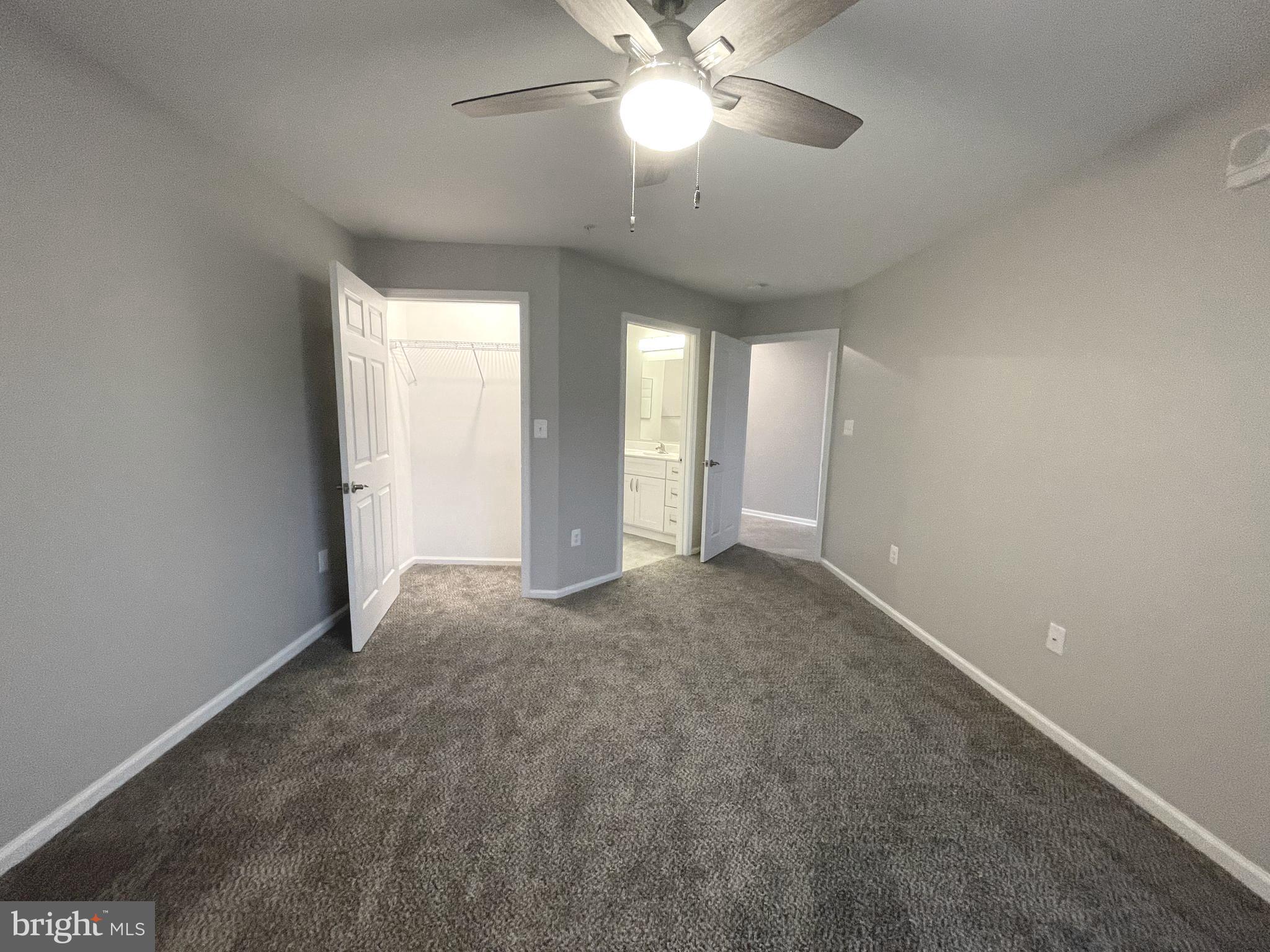2507 Shelley Circle, Unit 42B Frederick, MD 21702 - Photo 10 of 30 an empty room with a chandelier fan and windows