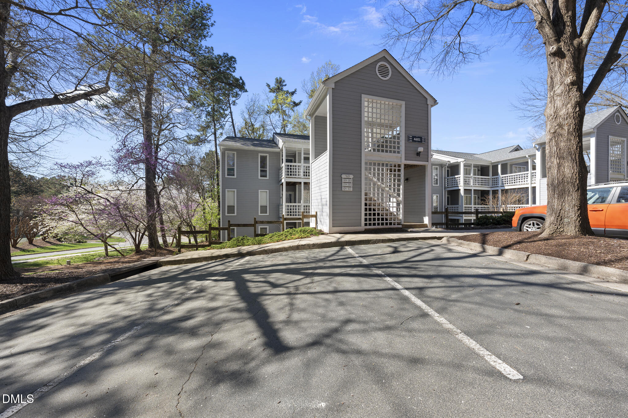 4601 Timbermill Court, Unit 104 Raleigh, NC 27612 - Photo 2 of 24 a view of a brick building next to a road with large trees