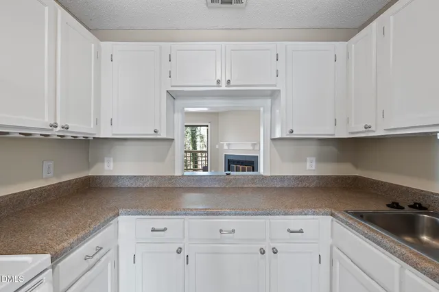 a kitchen with white cabinets and a sink