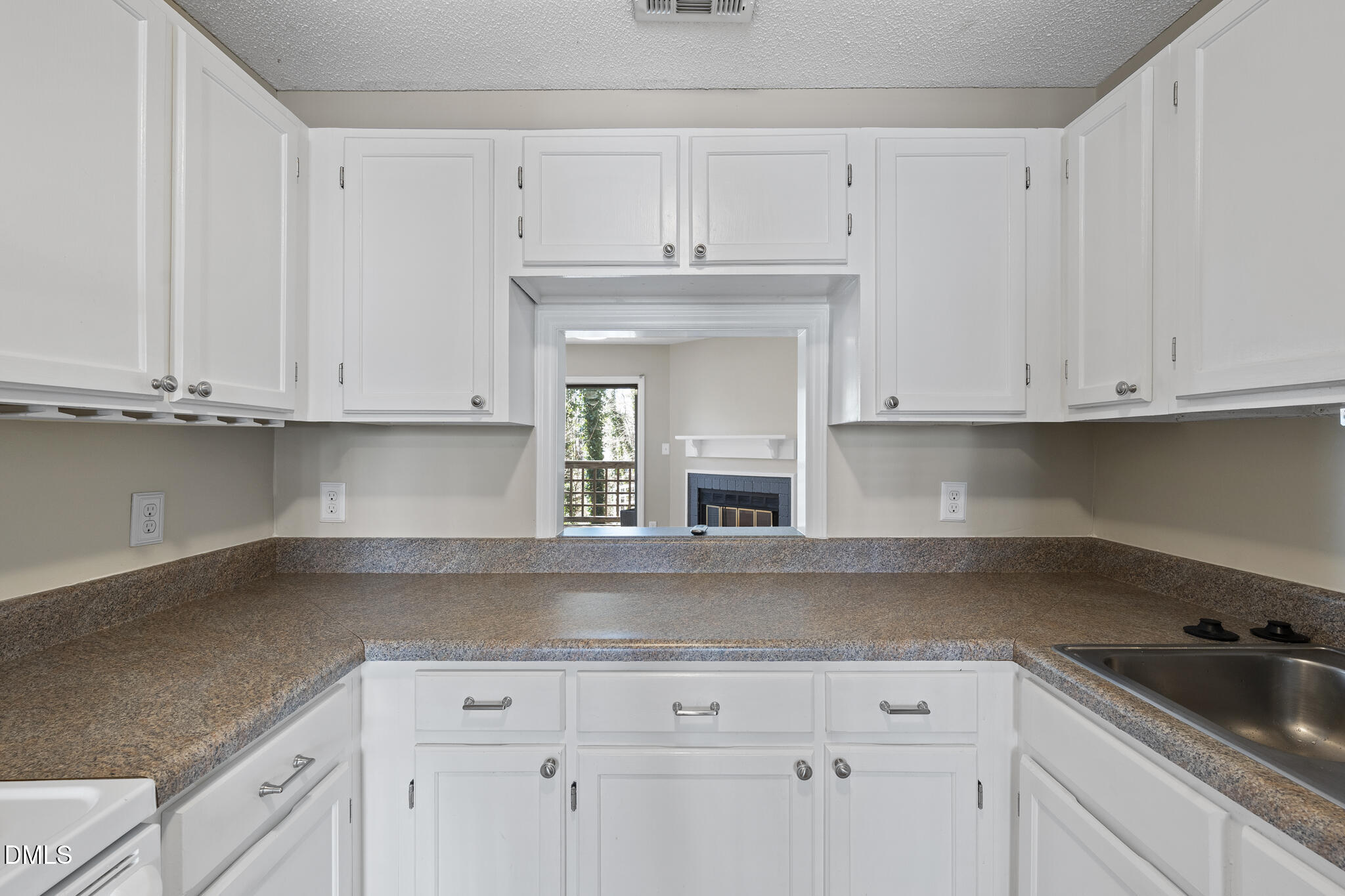 4601 Timbermill Court, Unit 104 Raleigh, NC 27612 - Photo 5 of 24 a kitchen with white cabinets and a sink