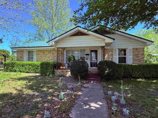 a view of a house with yard and chairs