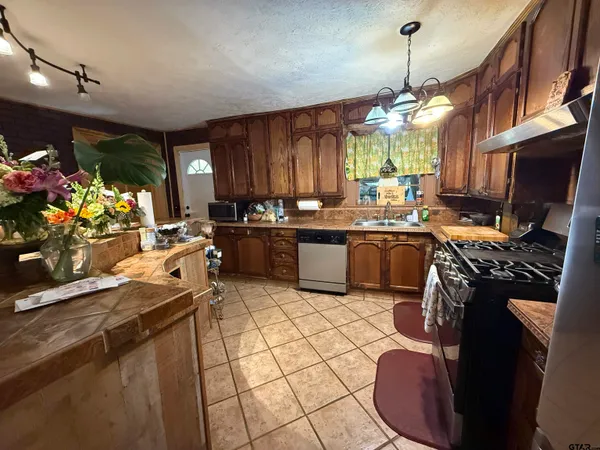 a kitchen with stainless steel appliances granite countertop a sink stove and cabinets