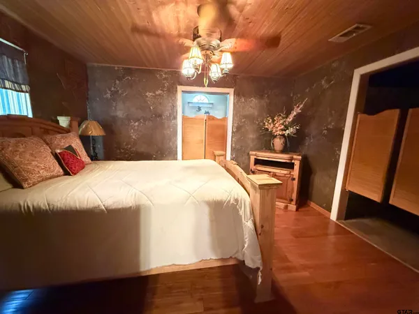 a bedroom with a bed and a mirror on dresser