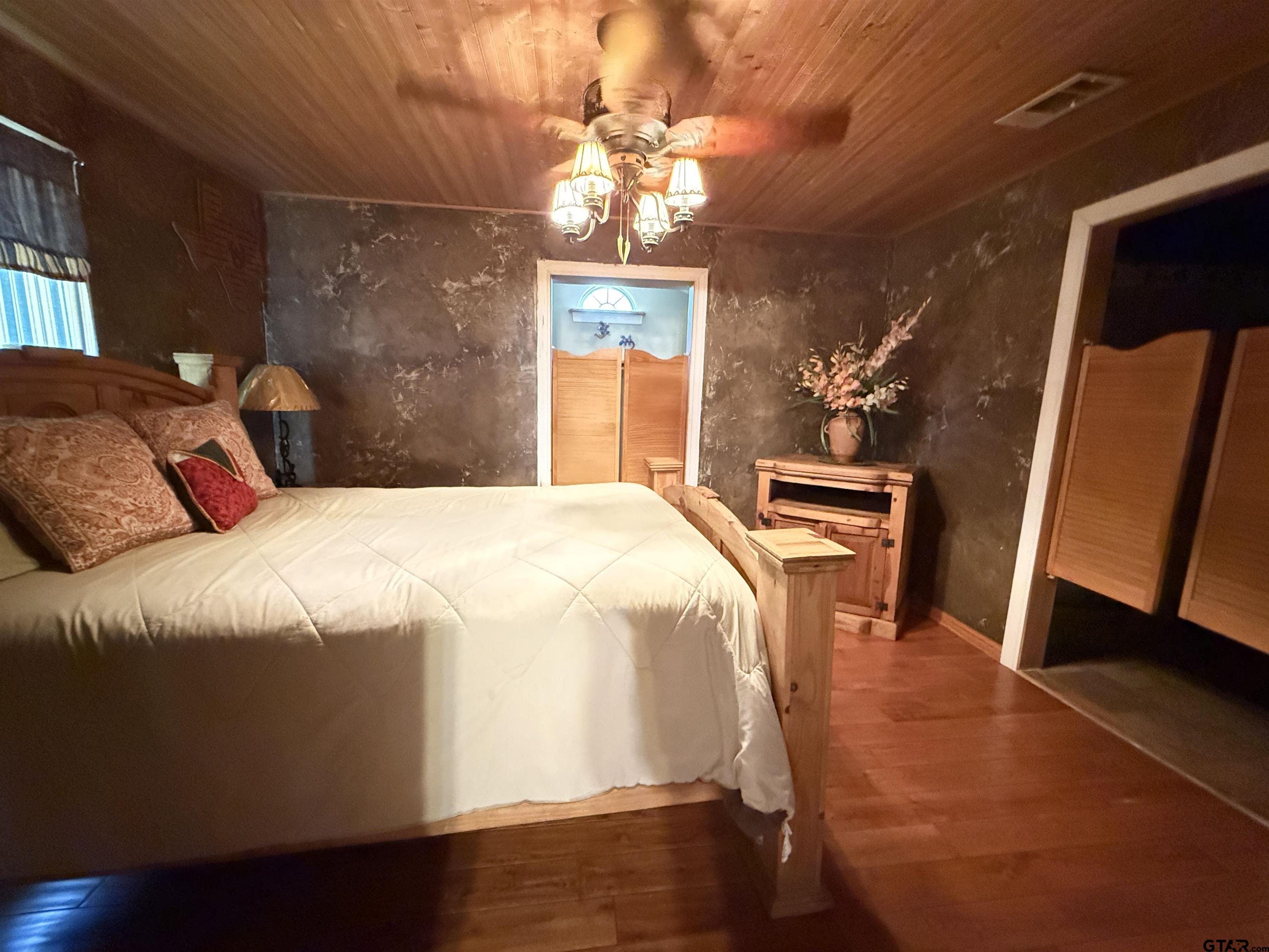 508 Whippoorwill Street Henderson, TX 75652 - Photo 12 of 24 a bedroom with a bed and a mirror on dresser