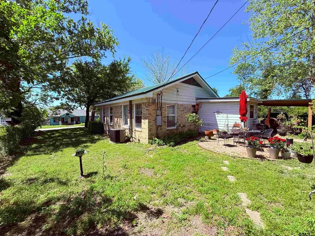 a view of a house with backyard sitting area and garden