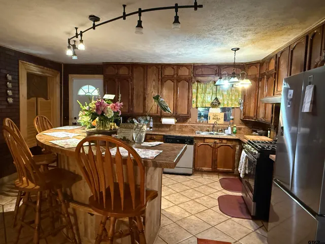 a kitchen with stainless steel appliances a table chairs and chandelier