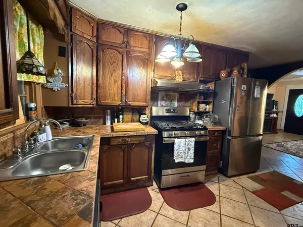 a kitchen with kitchen island granite countertop a sink cabinets and stainless steel appliances