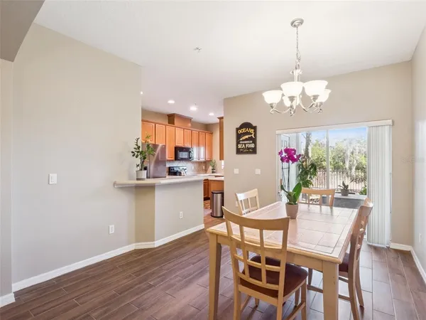 a view of a dining room with furniture a chandelier and wooden floor