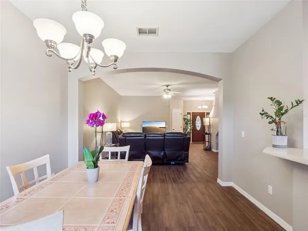 a view of a dining room with furniture a chandelier and wooden floor