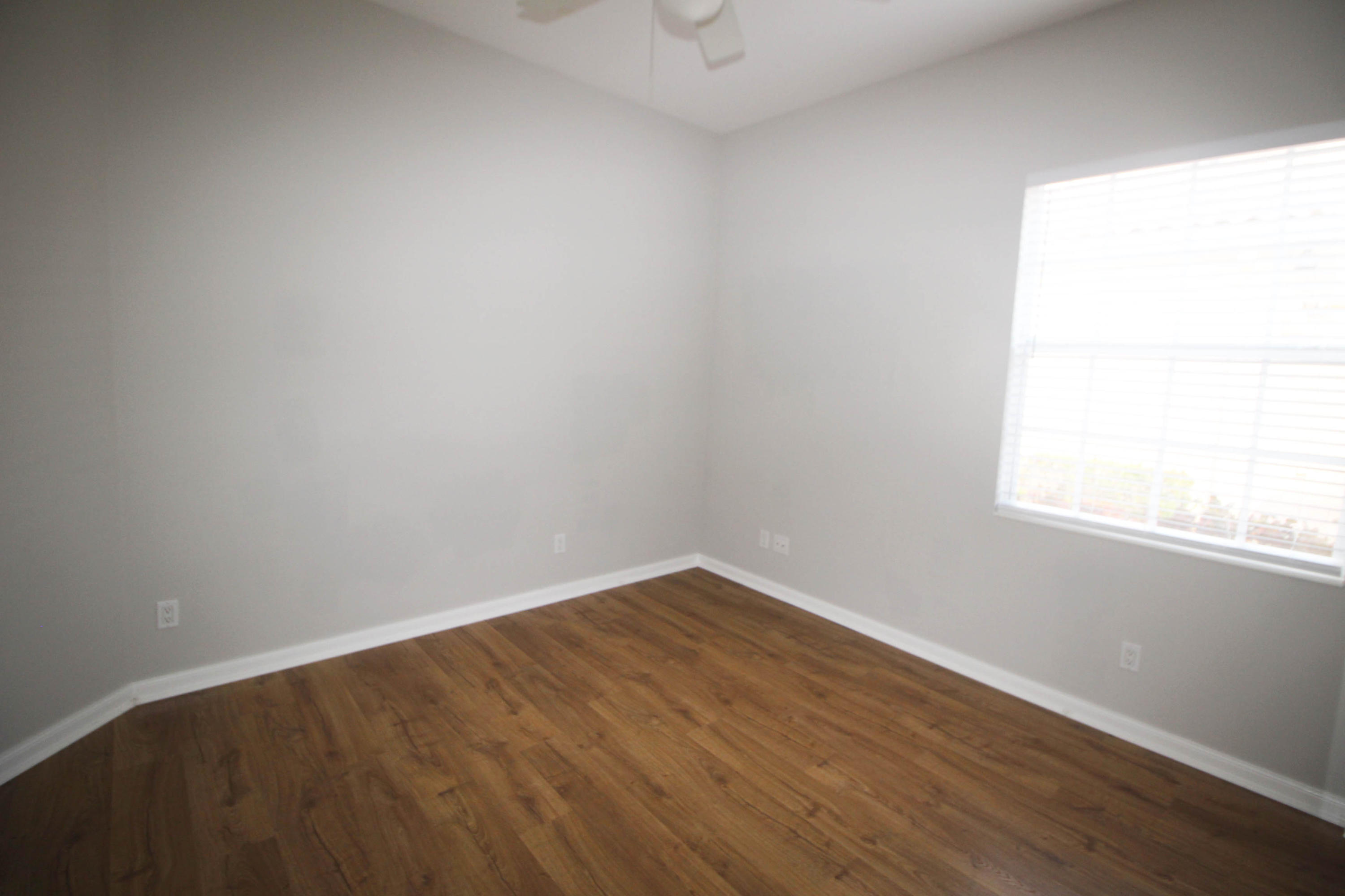 256 San Remo Drive Jupiter, FL 33458 - Photo 14 of 66 an empty room with wooden floor and windows