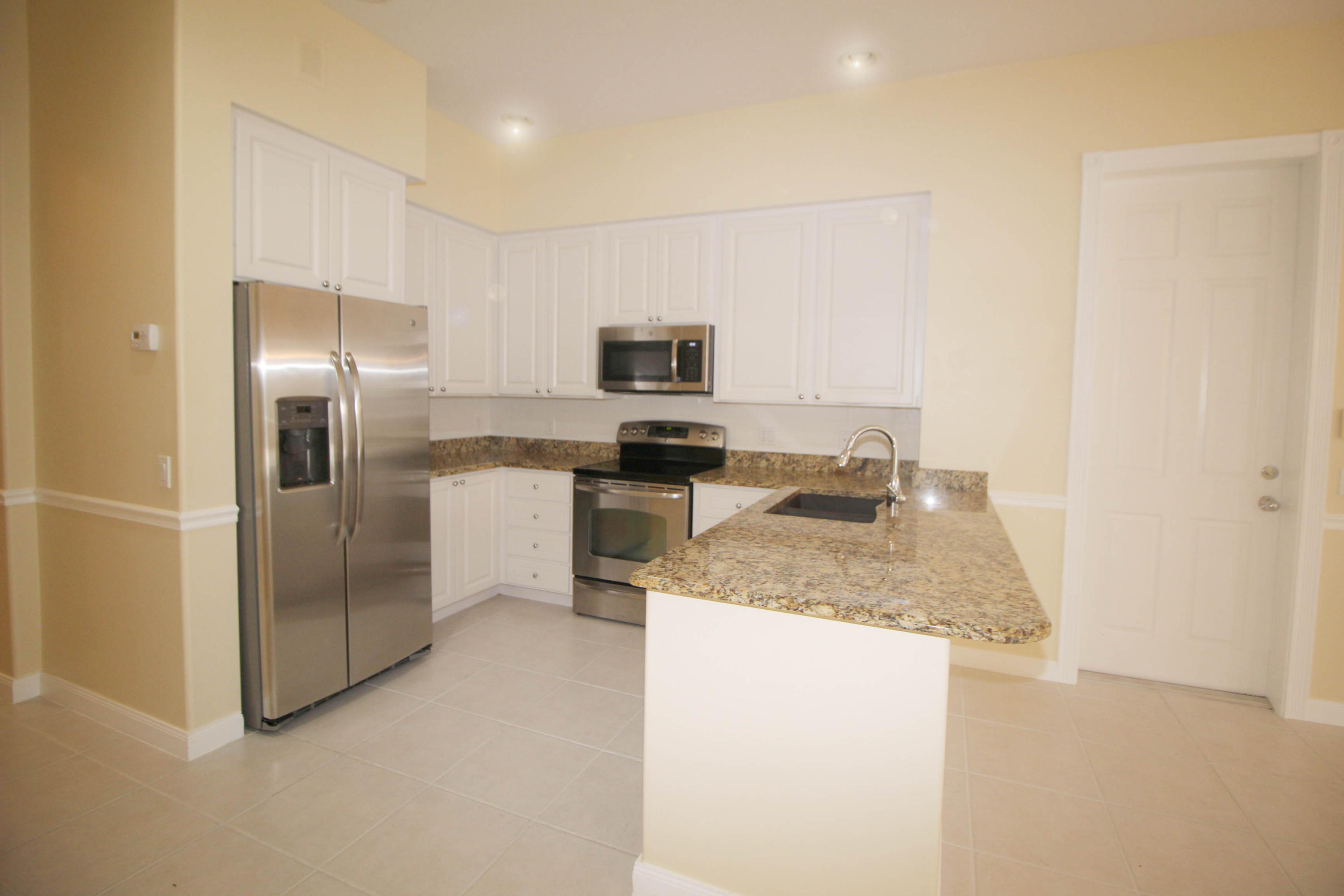 256 San Remo Drive Jupiter, FL 33458 - Photo 42 of 66 a kitchen with a refrigerator stove and a sink