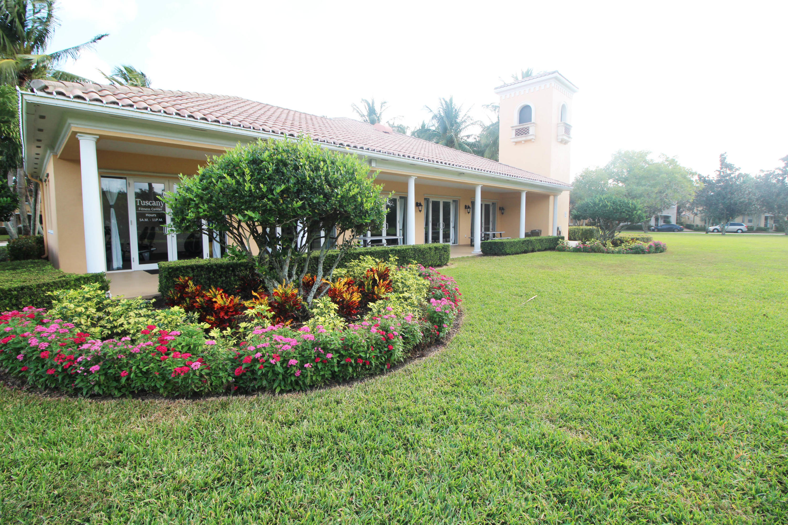 256 San Remo Drive Jupiter, FL 33458 - Photo 63 of 66 a front view of a house with a yard and potted plants