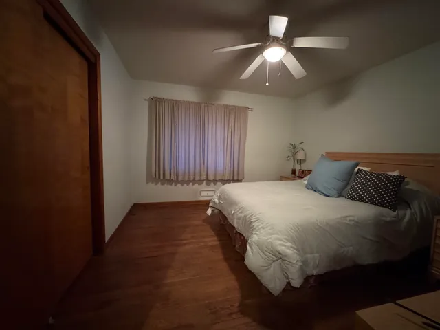 a bed sitting in a bedroom next to a window and a chandelier