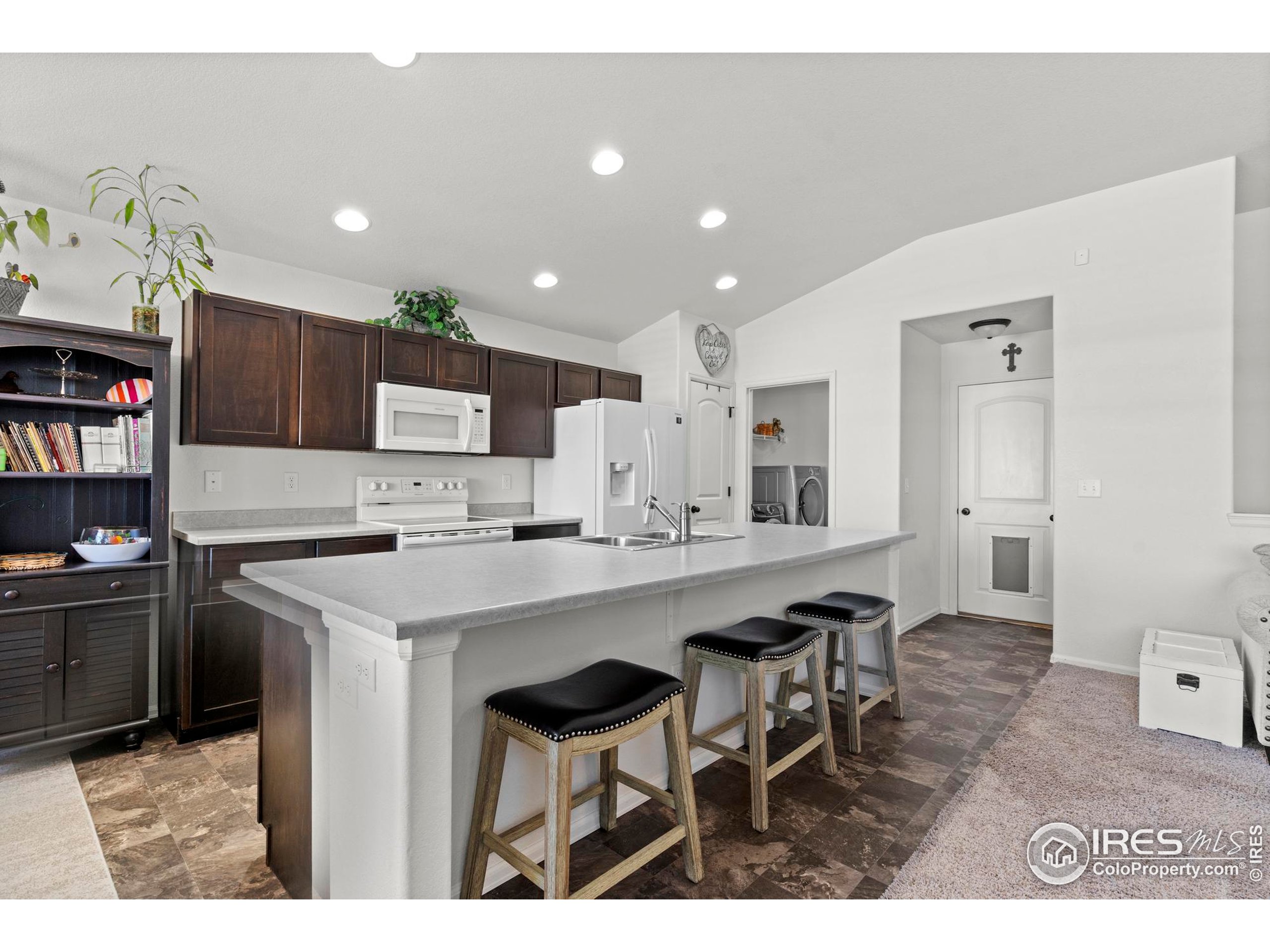 941 Barasingha Street Severance, CO 80550 - Photo 13 of 46 a kitchen with cabinets and chairs
