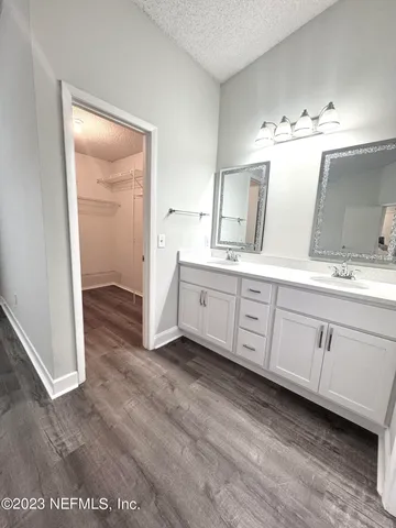 a spacious bathroom with a double vanity sink and a mirror