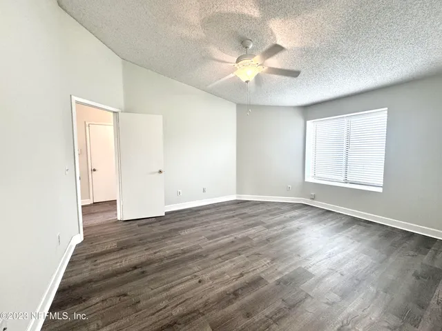 an empty room with wooden floor and window
