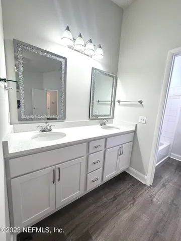 a bathroom with a double vanity sink and a mirror