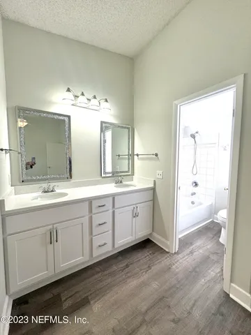 a spacious bathroom with a granite countertop sink and a mirror