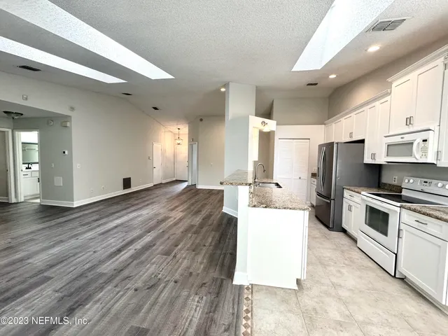 a large white kitchen with a large window