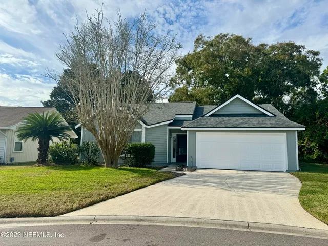 a front view of a house with a yard and trees