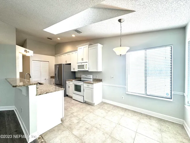 a kitchen with kitchen island white cabinets and white appliances