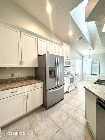 a kitchen with stainless steel appliances granite countertop a refrigerator sink and cabinets
