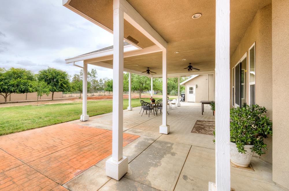 17465 Monreal Road Madera, CA 93636 - Photo 13 of 59 a view of a patio with a table and chairs potted plants with wooden fence