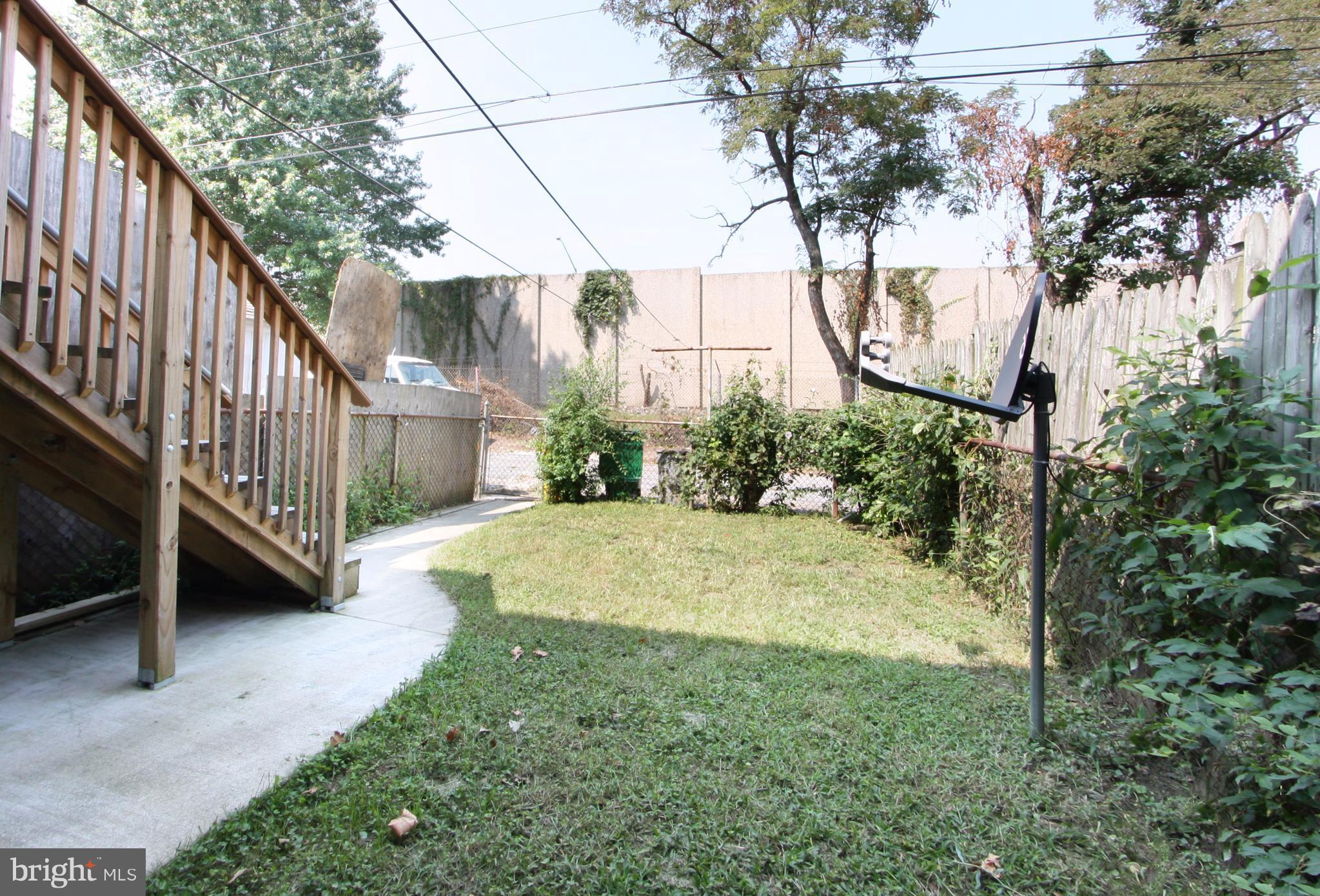 204 Old Riverside Road Baltimore, MD 21225 - Photo 20 of 24 a view of a yard with wooden fence and a tree