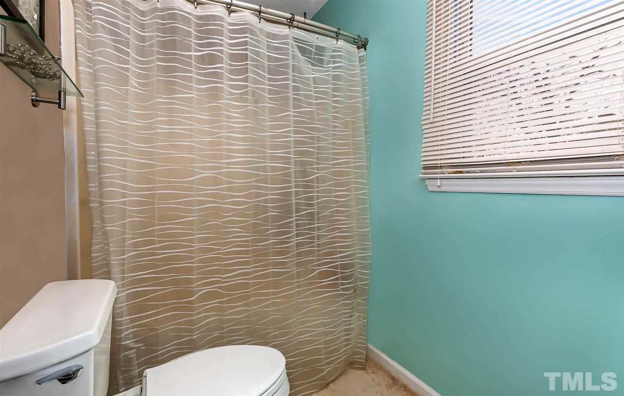 113 Tanning Ridge Drive Dunn, NC 28334 - Photo 22 of 28 a bathroom with a toilet and a shower curtain