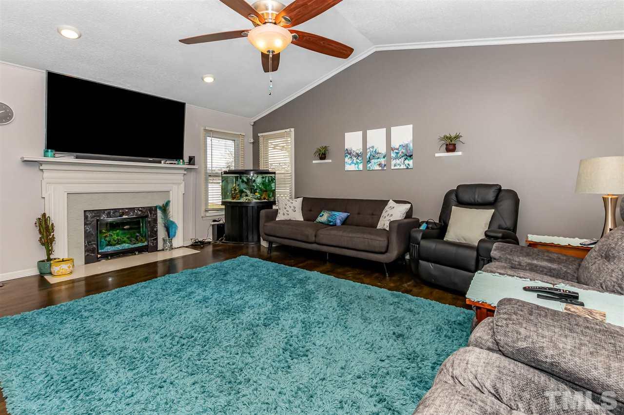 113 Tanning Ridge Drive Dunn, NC 28334 - Photo 8 of 28 a living room with furniture a flat screen tv and a fireplace
