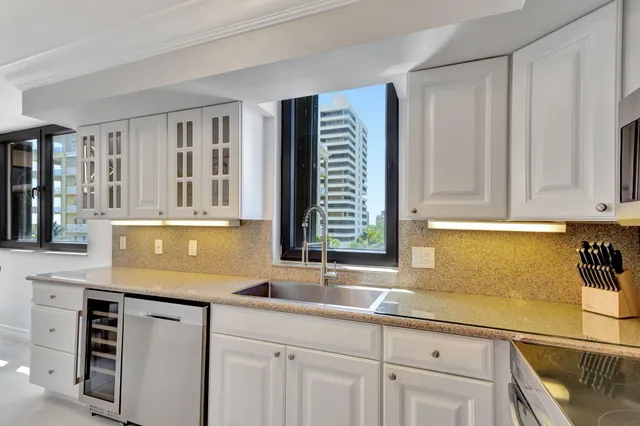 a kitchen with stainless steel appliances a dining table chairs and stove top oven