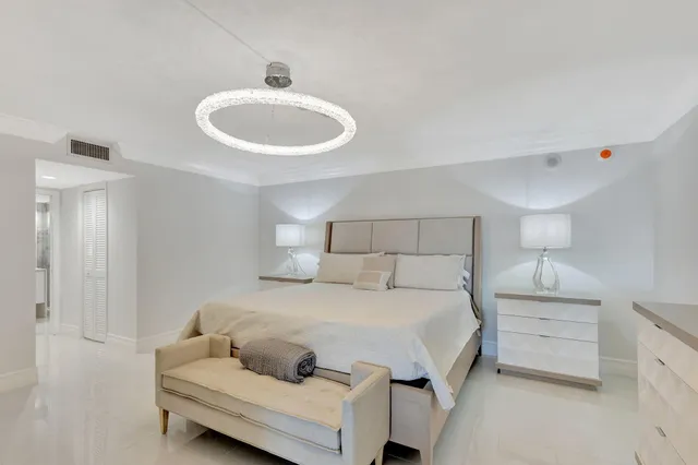 a bedroom with a bed flat screen tv and a large window