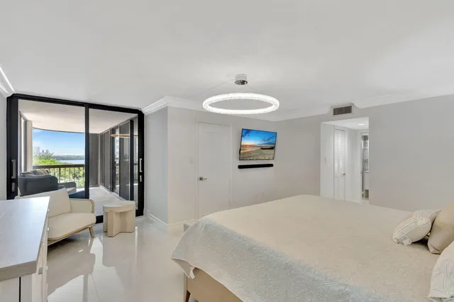 a bedroom with a bed and large windows