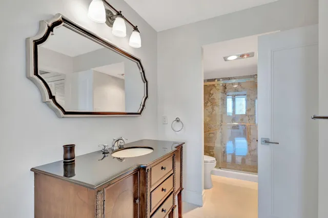 a view of a sign board with flower plants and large trees