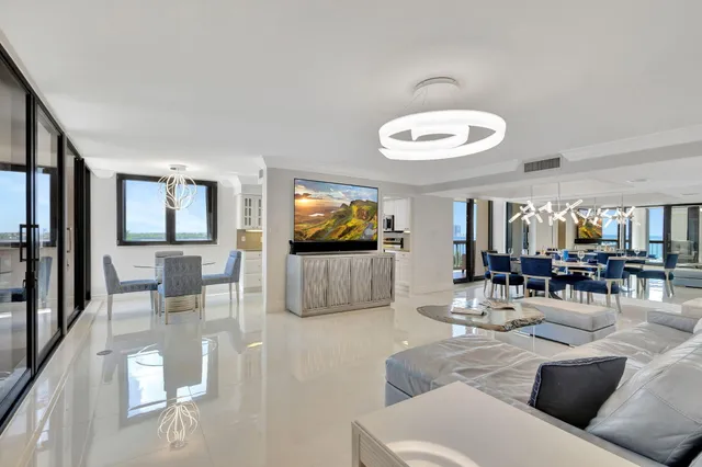 a living room with furniture a fireplace and a chandelier