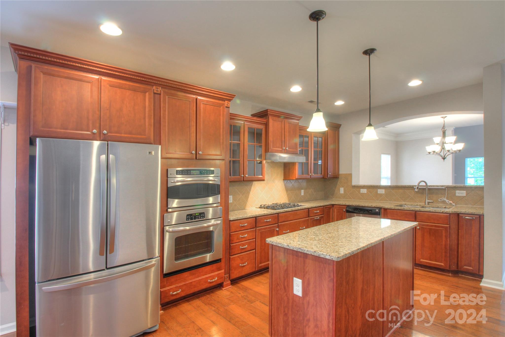 a kitchen with kitchen island a counter top space appliances and a center island