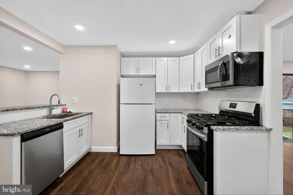 a kitchen with stainless steel appliances granite countertop a stove a sink and a refrigerator