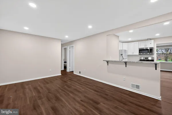 a view of kitchen with stainless steel appliances refrigerator stove microwave and cabinets