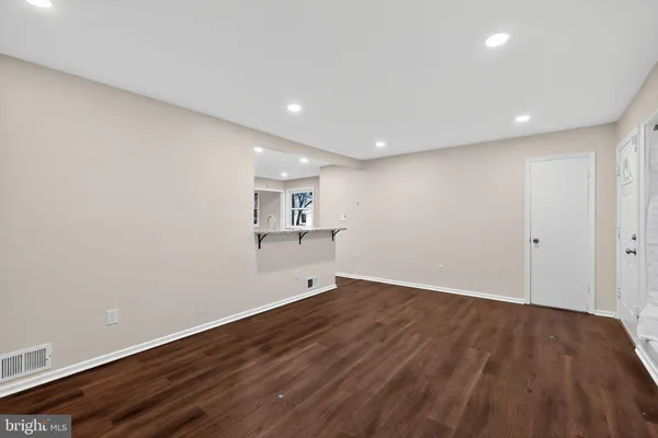 a view of empty room with wooden floor and fireplace
