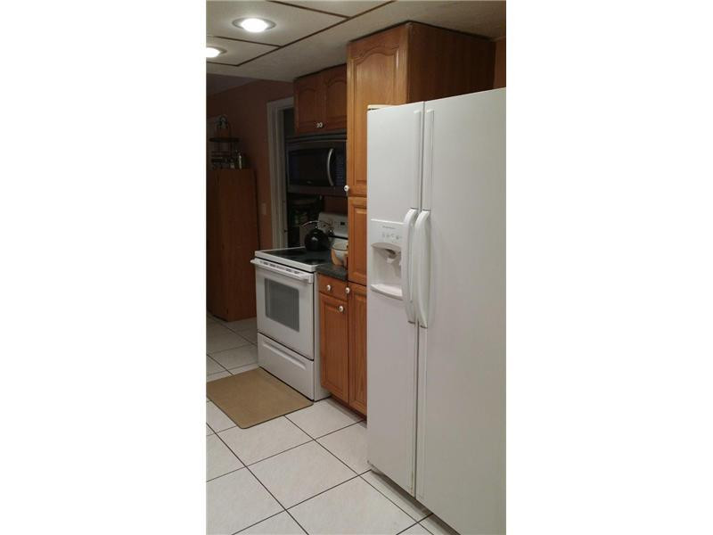 22173 Southwest 61st Avenue Boca Raton, FL 33428 - Photo 5 of 17 a kitchen with a refrigerator and cabinets