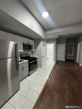 a kitchen with granite countertop a refrigerator and a stove top oven