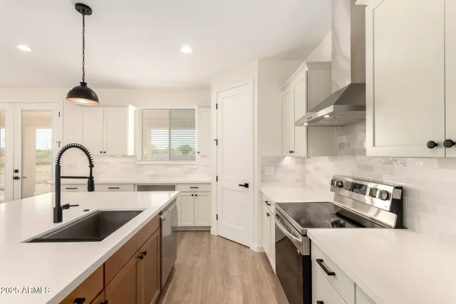 a kitchen with a sink a stove and cabinets