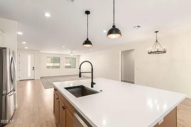 a kitchen with stainless steel appliances a sink a chandelier and a stove