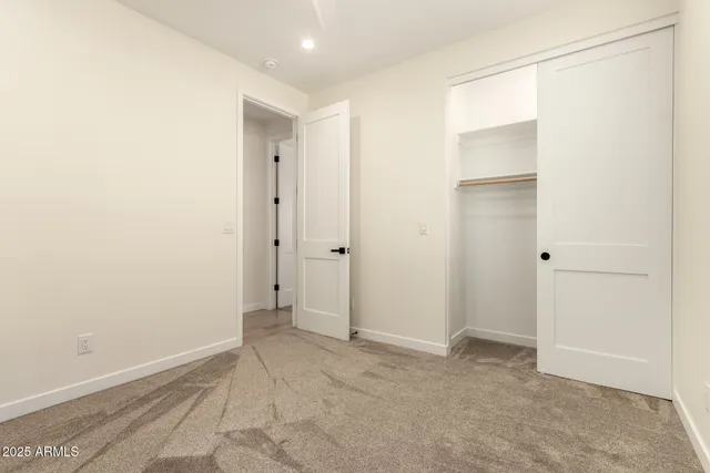 an empty room with a fan & a window